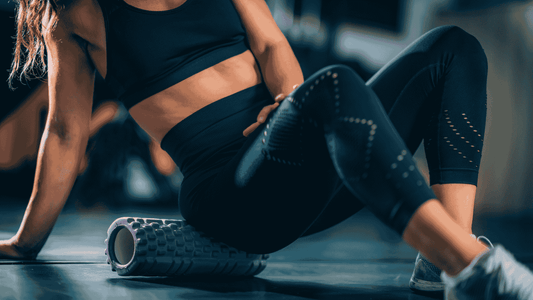 fit woman doing exercises with a foam roller